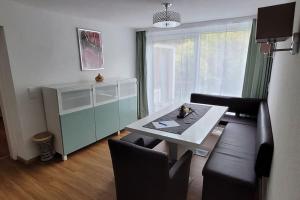 een woonkamer met een tafel en een bank bij Wohnung mit Garten, Sauna und Infrarotkabine 