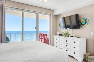 - une chambre avec un lit, une télévision et un balcon dans l'établissement Ocean Villa 1303, à Panama City Beach