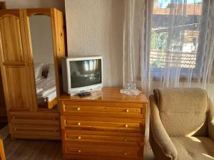 a television sitting on a dresser next to a window at Guest House Lina in Koprivshtitsa