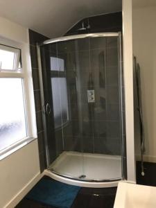a shower with a glass door in a bathroom at City Center House, Cardiff, parking permit and garden in Cardiff