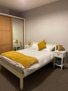 a bedroom with a bed with a yellow blanket on it at City Center House, Cardiff, parking permit and garden in Cardiff