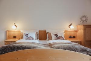 a large bed with two dogs on the pillows at Oberaldoss Residence Wellness in Santa Cristina in Val Gardena