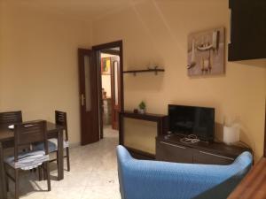 a living room with a television and a table and chairs at Casa Aymerich in Bellpuig