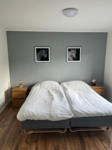 1 dormitorio con 1 cama blanca y 2 mesitas de noche en Furuvägen 11 C, en Ullared