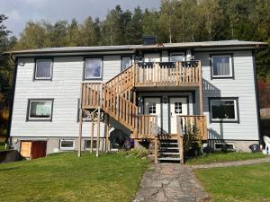 ein Haus mit einer Holzterrasse und einer Treppe in der Unterkunft Furuvägen 11 C in Ullared