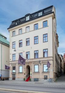 a large white building with purple flags in front of it at Hotel Gamla Stan, BW Signature Collection in Stockholm