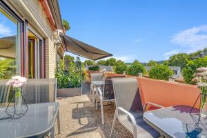 a patio with tables and chairs on a balcony at Hotel Marktterrassen in Hennef +32 photos