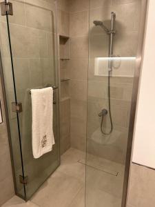 a shower with a glass door and a towel at Madinat Jumeirah Living One bedroom apartment in Dubai