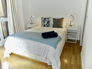 馬德里的住宿－Precioso apartamento junto a la Plaza Mayor，一间卧室配有一张白色的床和蓝色的毯子