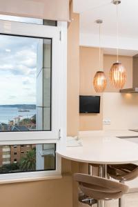 cocina con ventana grande, mesa y sillas en Apartamento Junto Playa Sardinero Con Parking en Santander