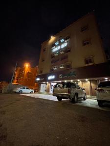 un edificio con auto parcheggiate di fronte ad esso di notte di ركن الهدوء a Muhayil
