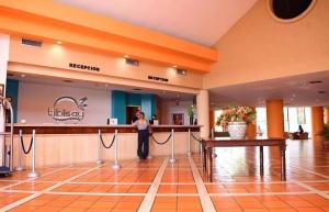 a woman standing at a counter in a hotel lobby at Tibisay Hotel Maturin in Maturín