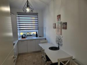 a white kitchen with a table and a window at OSCAR HOUSE in Braşov