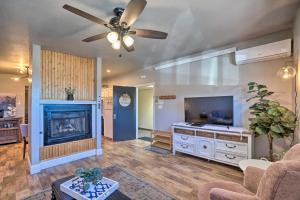 a living room with a fireplace and a ceiling fan at Luxe Route 66 Getaway with AC in Downtown! in Williams