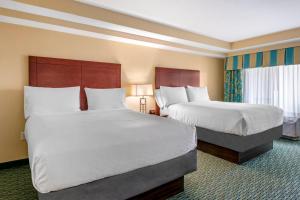 um quarto de hotel com duas camas com lençóis brancos em Holiday Inn Resort Orlando - Lake Buena Vista, an IHG Hotel em Orlando