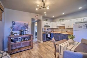 a kitchen with blue cabinets and a table and a dining room at Luxe Route 66 Getaway with AC in Downtown! in Williams