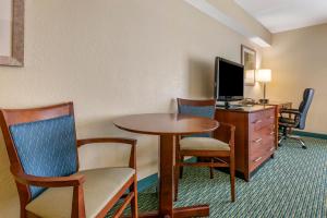 a hotel room with a desk and a table and chairs at Holiday Inn Resort Orlando - Lake Buena Vista, an IHG Hotel in Orlando