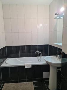 a bathroom with a tub and a sink at OSCAR HOUSE in Braşov