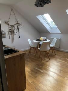 una cucina e una sala da pranzo con tavolo e sedie di Apartament Kendal a Dźwirzyno