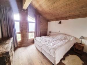 sypialnia z dużym łóżkiem w pokoju z drewnianym sufitem w obiekcie Appartement Les Saisies, 4 pièces, 8 personnes - FR-1-293-370 w mieście Hauteluce