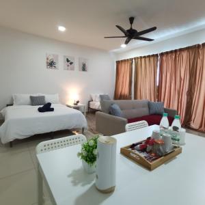 uma sala de estar com duas camas e um sofá em NH Homestay Trefoil em Kuala Selangor