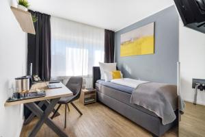 Pokój hotelowy z łóżkiem i biurkiem z biurkiem w obiekcie Hotel garni Marktterrassen w mieście Hennef