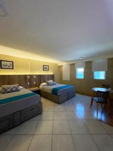 Habitación de hotel con 2 camas y mesa en EXECUTIROOMS VERACRUZ, en Veracruz