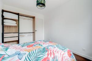 1 dormitorio con 1 cama con un edredón colorido en Le Petit Calypso, en Nancy