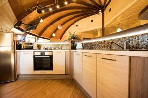cocina grande con armarios de madera y techo abovedado en Okrągły dom z bala Arena SPA sauna, jacuzzi!, en Krąg