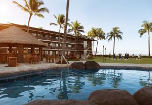 un complexe avec une grande piscine et des palmiers dans l'établissement Koa Kea Resort on Poipu Beach, à Koloa