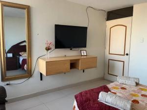 uma sala de estar com televisão e espelho em Lindo y Céntrico MiniDepartamento I em Trujillo