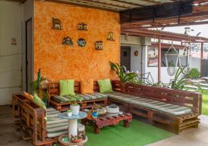 d'une terrasse avec un canapé en bois et une table. dans l'établissement Eco Stay Hostel, à San José