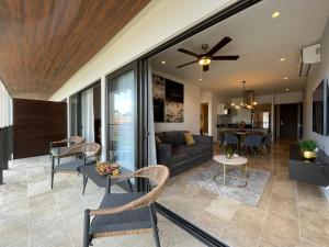 a living room and dining room with a ceiling fan at New & Equipped Apartment Steps From The Beach With Pool Jacuzzi By Yeah in Playa del Carmen