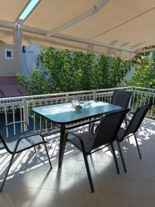 een tafel en stoelen op een patio met een parasol bij Alpha apartment, Ireon Samos in Iraion