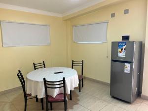 a dining room with a table and a refrigerator at Dtos las brisas in La Banda