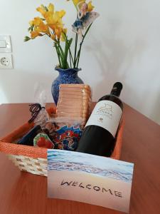 a basket with a bottle of wine and a vase at Alpha apartment, Ireon Samos in Ireon