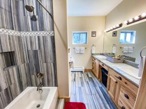 La salle de bains est pourvue d'une douche, de 2 lavabos et d'une baignoire. dans l'établissement New! Beautiful, Spacious Modern Home on a Large Acreage - Peaks & Prairies Retreat, à Antero Junction