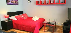 - une chambre avec un lit rouge et une couverture rouge dans l'établissement APARTMENT LUXURY OASIS Śródmieście DOWNTOWN 3 os, à Cracovie