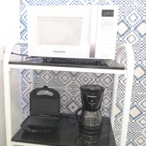 um micro-ondas e comodidades para preparar café numa prateleira em Flat Recanto do Sertão em Piranhas