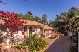 un complejo con flores rosas en una terraza de madera en Pousada Boa Vista, en Barreirinhas