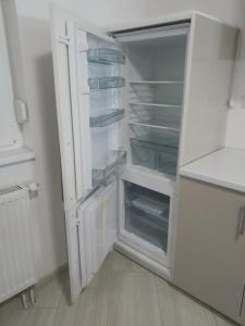 a white refrigerator with its door open in a kitchen at Apartman XXL in Brčko