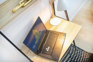 einen Laptop auf einem Tisch neben einer Lampe in der Unterkunft Bannermill Place Lodge ✪ Grampian Lettings Ltd in Aberdeen