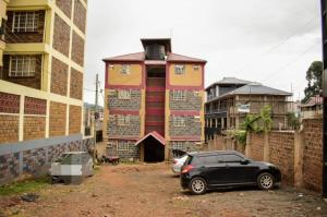 a black car parked in front of a building at Woodgreek Studio Apartment 4B27 in Kisii