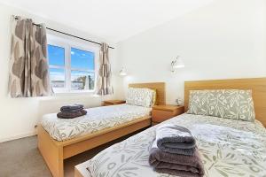 a bedroom with two beds and a window at Bannermill Place Lodge ✪ Grampian Lettings Ltd in Aberdeen