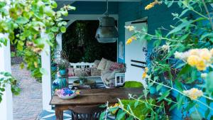 a porch with a wooden table and some flowers at Wonderland in Pieterburen