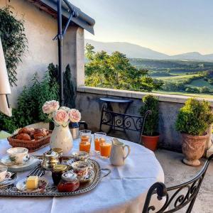 a table with breakfast food on a balcony with a view at Six chandelles m'étaient comptées in Puimoisson