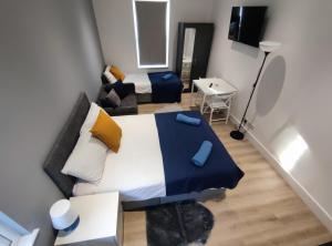 een kleine slaapkamer met een bed en een bank bij STUNNING STUDIO In NORTH LONDON - VICTORIA LINE in Londen