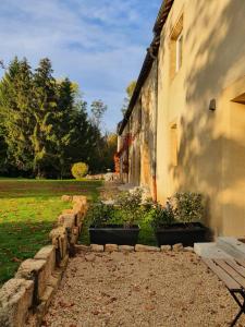 a building with a stone pathway next to a yard at La Jonquette in Francheval