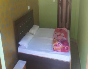 a small bed in a room with white sheets and a pillow at Tirath Niwas by StayApart in Kharsālī