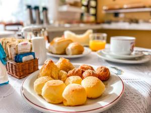 two plates of pastries and bread on a table at Hotel Parque Atlântico in Ubatuba